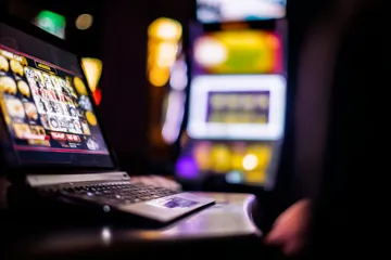 Một cô gái mỉm cười bên cạnh các máy slot sáng rực với biểu tượng may mắn, thể hiện danh mục slot nổi bật của BL5558-58L.